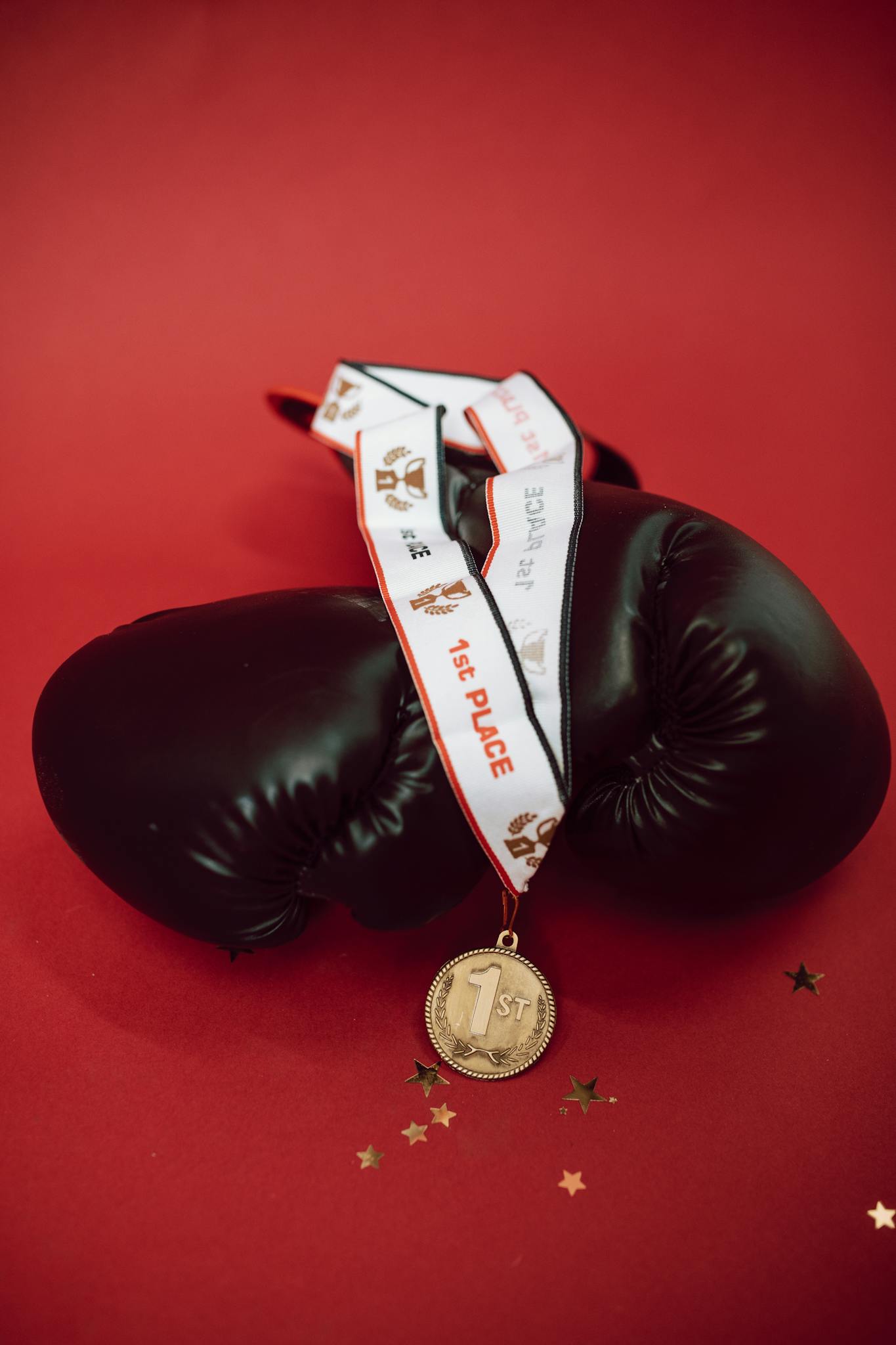 Golden first place medal draped on boxing gloves symbolizes victory and achievement in sports.