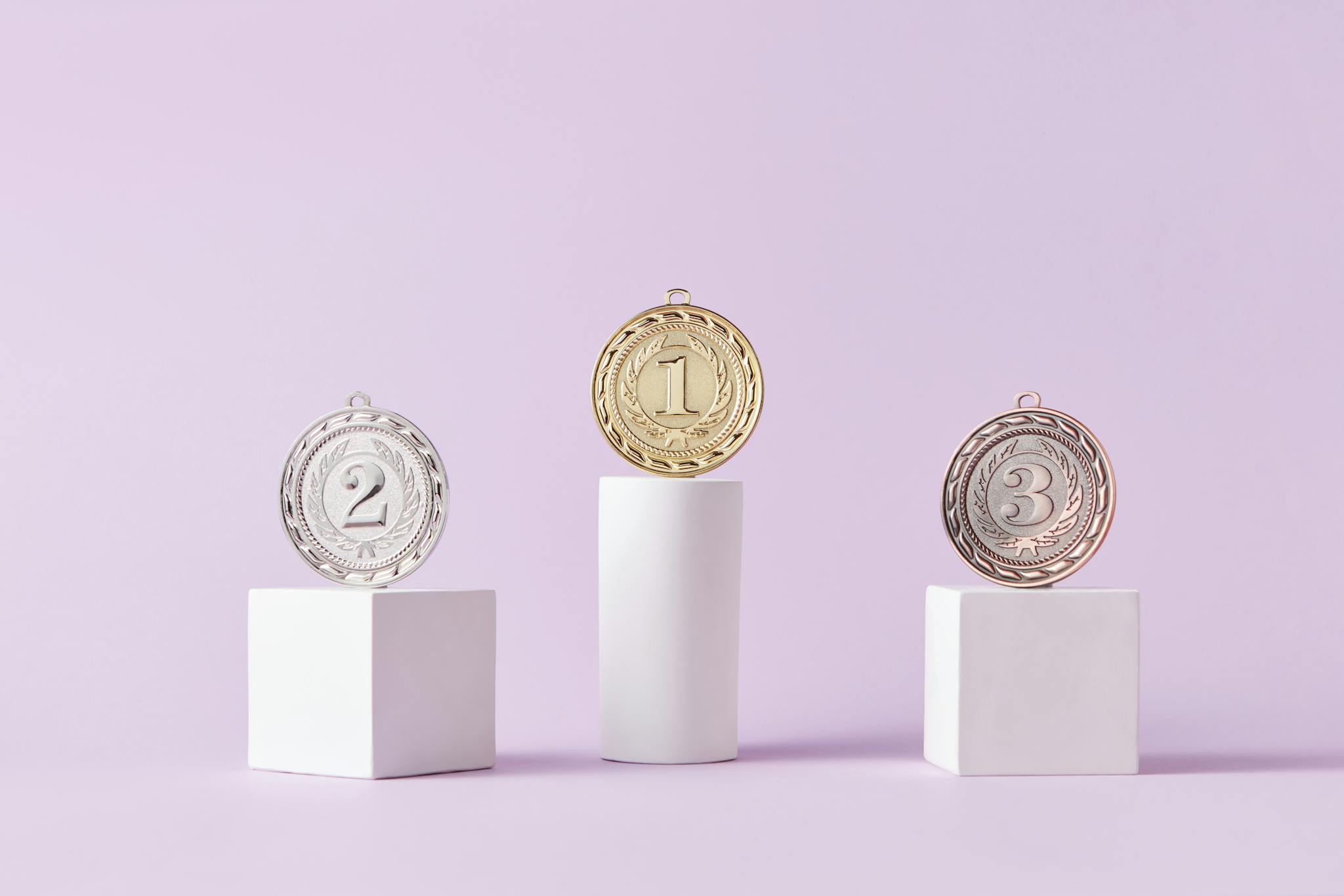 Medals on a podium against a soft pastel background, ideal for awards themes.
